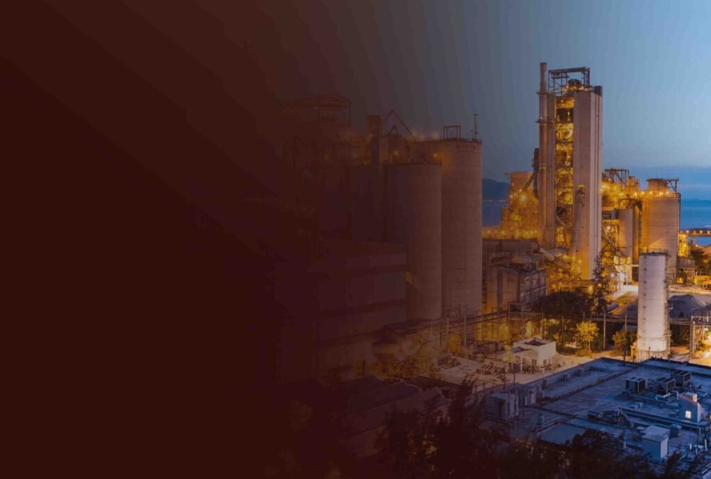 An industrial manufacturing plant lit up at dusk